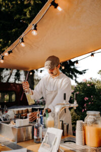 barman qui fait des cocktails minute pour le mariage pendant l'apéritif dans son van aménagé. Cocktail Van & Co