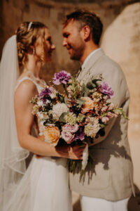 photo de couple de près avec le bouquet de la mariée composé d'oeillets, lisianthus à la chapelle Saint Véran à Orgon