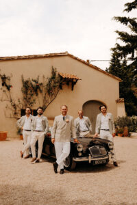 le marié avec ses témoins et garçon d'honneur devant la voiture de location qui est une MG ancienne de collection. Devant la grange du mas des costes