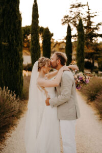 photo de couple dans l'allée de cyprès au mas des costes à orgon dans les alpilles en provence, entouré d'un champ de lavandes