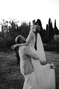 photo des mariés en noir et blanc lors du coucher de soleil, le marié porte la mariée